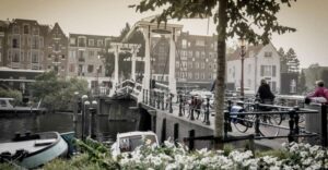 Amsterdam: Guided City Bike Tour in French - Getting in motion at IJdok 47: meeting point, shoes, and bike basics